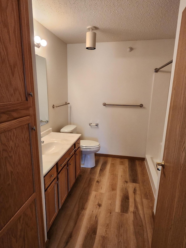 2155 6th Ln SE Unit 301, Cambridge, MN 55008 - bathroom with vanity, wood finished floors, a shower, and a textured ceiling