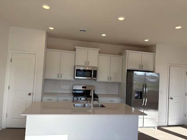 22648 Isla Way, Rogers, MN 55374 - kitchen featuring appliances with stainless steel finishes, recessed lighting, a center island with sink, tasteful backsplash, and white cabinets
