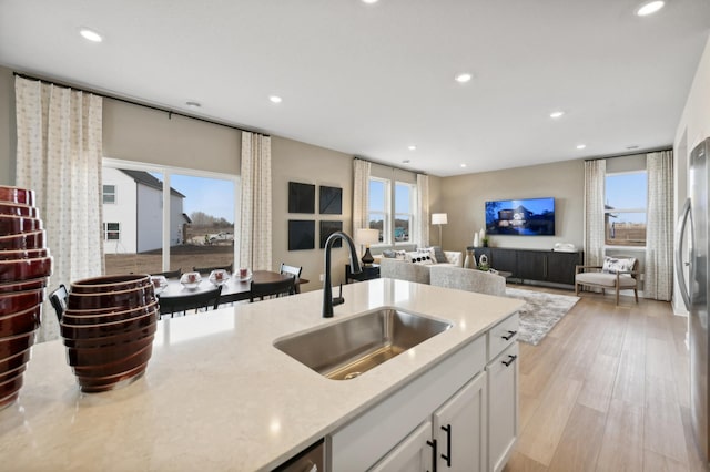 22648 Isla Way, Rogers, MN 55374 - kitchen with a sink, recessed lighting, white cabinets, light wood-style floors, and open floor plan
