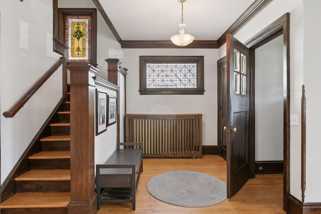 interior space featuring crown molding, baseboards, and wood finished floors