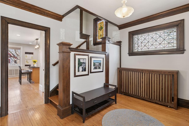 hall featuring baseboards, ornamental molding, hardwood / wood-style flooring, and stairway