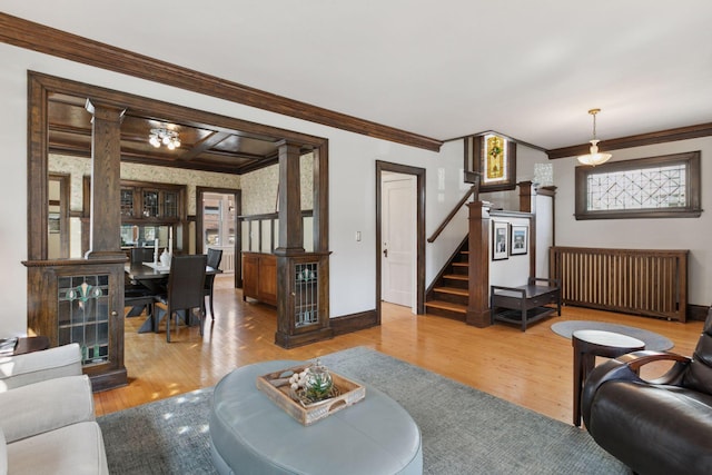 living area with stairs, ornate columns, baseboards, and wood finished floors