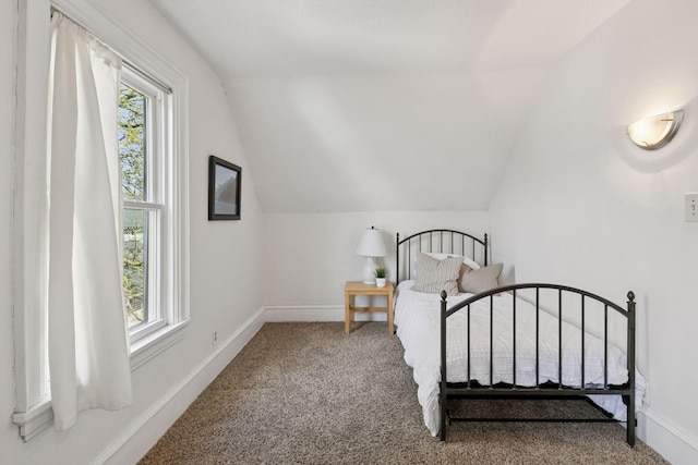 bedroom with carpet floors, vaulted ceiling, and multiple windows