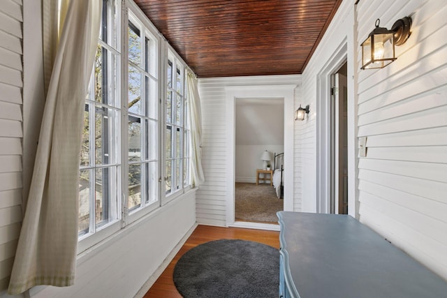sunroom featuring french doors, wooden ceiling, a healthy amount of sunlight, and wood finished floors