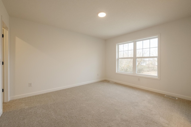 spare room featuring carpet, baseboards, and recessed lighting