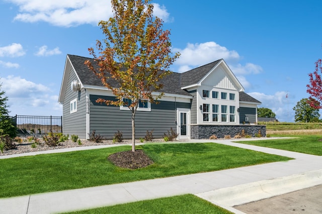 view of front of home with roof with shingles, stone siding, and board and batten siding