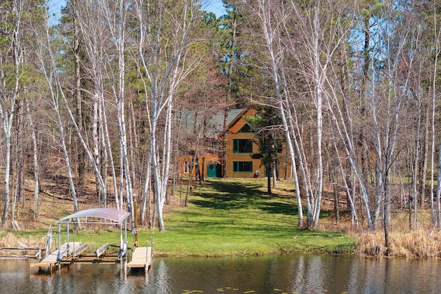 dock with boat lift, a water view, and a lawn