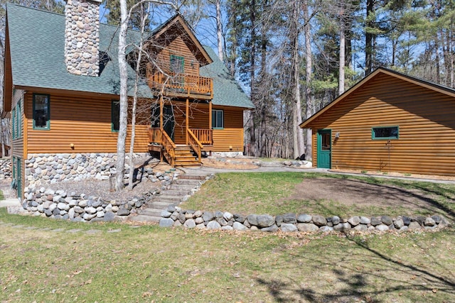 view of front of home with a shingled roof, a front lawn, a chimney, and faux log siding