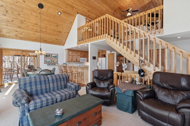 carpeted living area featuring high vaulted ceiling, wood ceiling, stairway, ceiling fan, and a chandelier