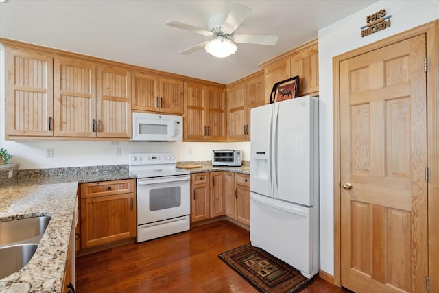 kitchen with white appliances, a ceiling fan, light stone counters, and dark wood finished floors