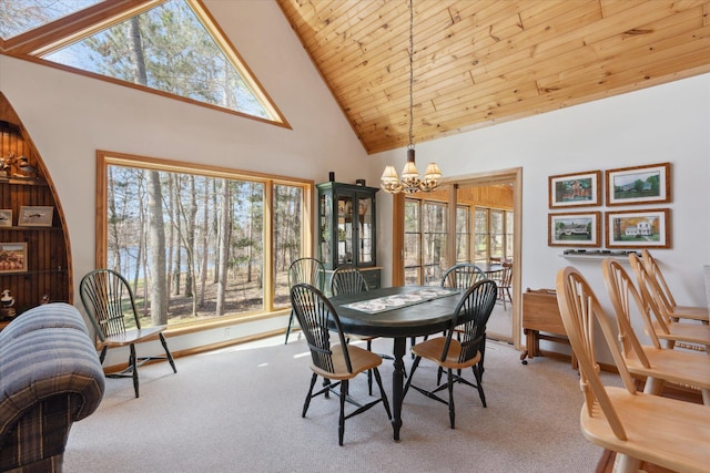 carpeted dining space with a chandelier, high vaulted ceiling, and wooden ceiling