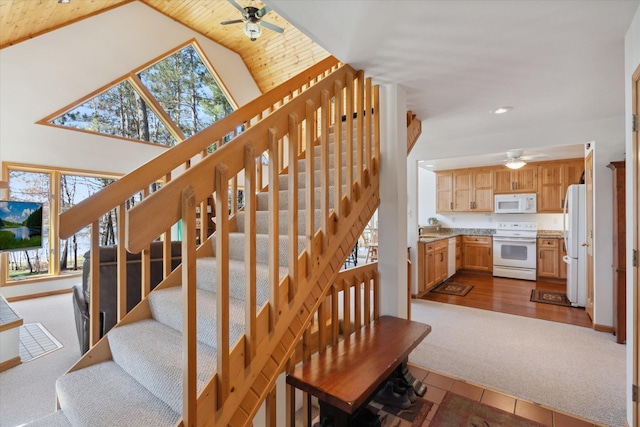stairs featuring a ceiling fan, healthy amount of natural light, carpet floors, recessed lighting, and high vaulted ceiling