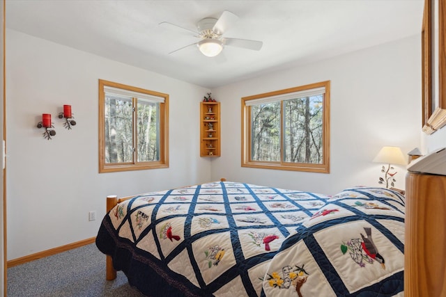 bedroom featuring multiple windows, carpet floors, baseboards, and a ceiling fan