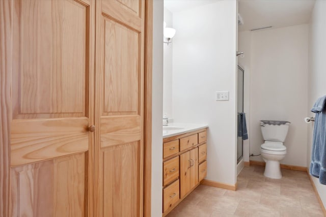 full bath with a shower stall, toilet, vanity, and baseboards