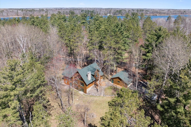 aerial view of property and surrounding area with a heavily wooded area and a large body of water