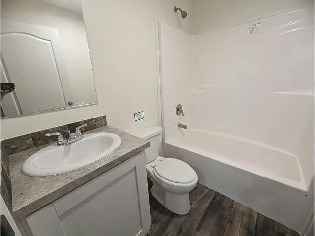 full bathroom with wood finished floors, toilet, vanity, and shower / bath combination