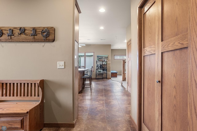 corridor featuring baseboards, recessed lighting, and tile patterned floors