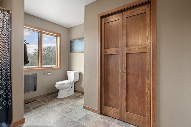 full bath with visible vents, toilet, baseboards, stone finish floor, and a shower with curtain
