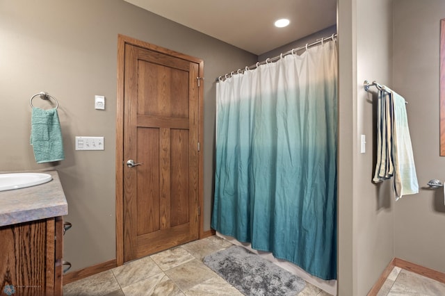 full bathroom featuring a shower with curtain, baseboards, and vanity