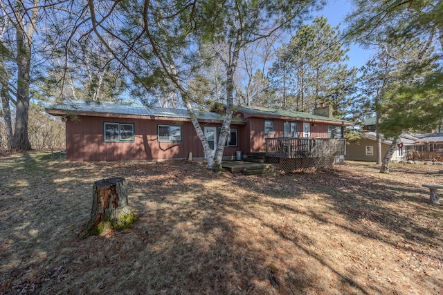 rear view of property with a chimney and a deck