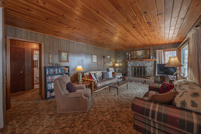 carpeted living area with wood walls, wood ceiling, and a stone fireplace