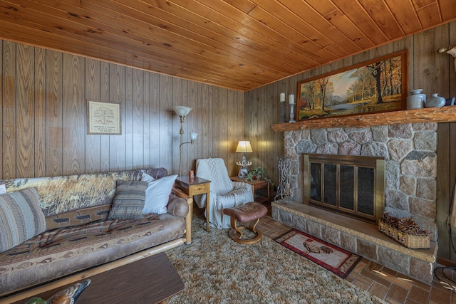 living area with wood ceiling, wood walls, and a stone fireplace