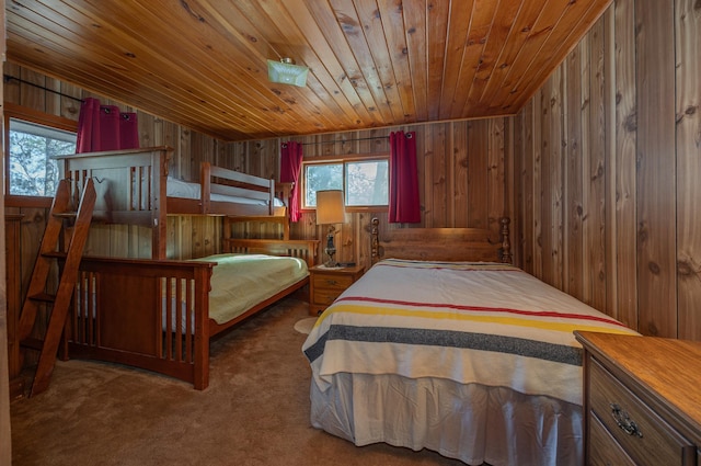 bedroom with carpet, wooden ceiling, wood walls, and multiple windows