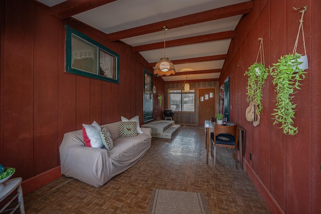 living area featuring wooden walls and beamed ceiling
