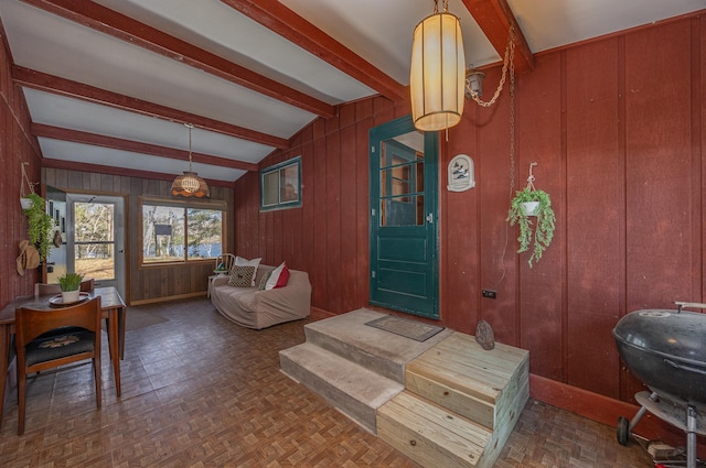 interior space with wood walls and vaulted ceiling with beams