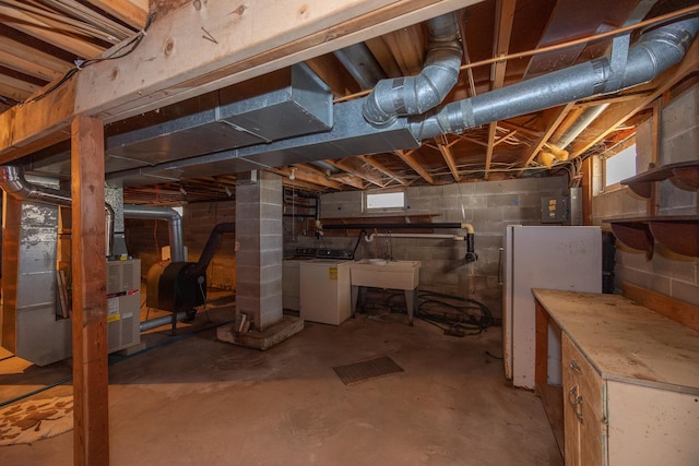below grade area with heating fuel, a healthy amount of sunlight, washer / clothes dryer, and a sink