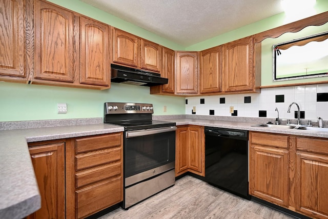 155 Nicholas Dr, Lewiston, MN 55952 - kitchen with stainless steel range with electric stovetop, dishwasher, under cabinet range hood, light wood-style flooring, and brown cabinetry