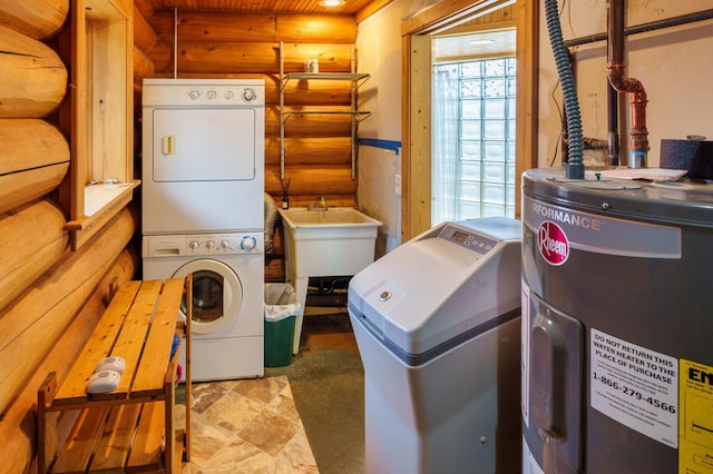 laundry room with water heater, stacked washer / drying machine, rustic walls, and a sink