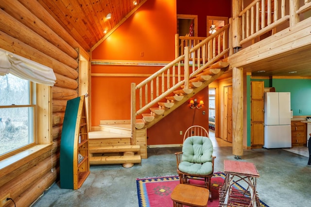 interior space featuring stairs, wooden ceiling, concrete flooring, log walls, and high vaulted ceiling