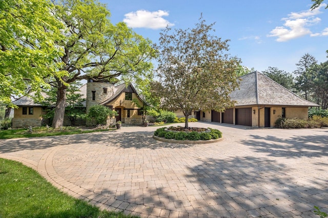 12535 Beach Cir, Eden Prairie, MN 55344 - view of front facade featuring stone siding, an attached garage, curved driveway, and stucco siding