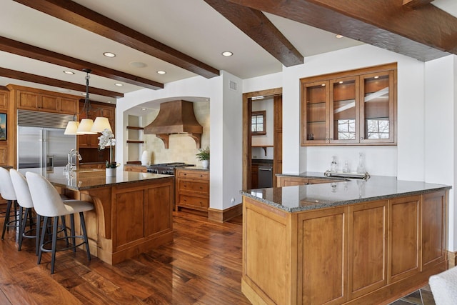 12535 Beach Cir, Eden Prairie, MN 55344 - kitchen featuring dark stone counters, stainless steel built in fridge, custom range hood, a peninsula, and dark wood-style floors