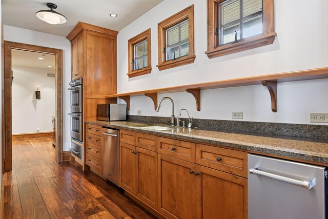 12535 Beach Cir, Eden Prairie, MN 55344 - kitchen featuring stainless steel appliances, a sink, dark stone countertops, and dark wood finished floors