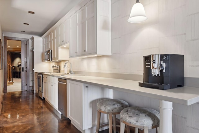 12535 Beach Cir, Eden Prairie, MN 55344 - kitchen with white cabinets, a breakfast bar, light countertops, a sink, and appliances with stainless steel finishes