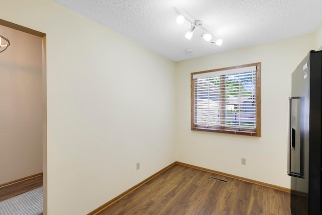 2672 Lake Court Dr Unit 58, Mounds View, MN 55112 - unfurnished dining area featuring dark wood-style floors, a textured ceiling, baseboards, and track lighting