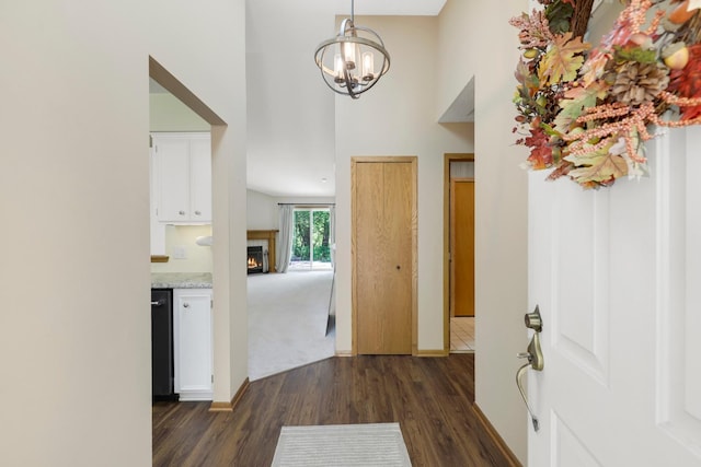 2672 Lake Court Dr Unit 58, Mounds View, MN 55112 - entrance foyer featuring dark wood-style floors, a chandelier, a towering ceiling, a lit fireplace, and baseboards