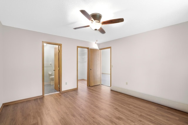 2672 Lake Court Dr Unit 58, Mounds View, MN 55112 - unfurnished bedroom with a walk in closet, light wood-type flooring, a closet, baseboards, and ensuite bathroom