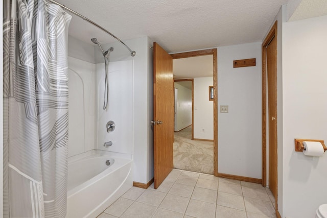 bathroom with baseboards, a textured ceiling, tile patterned floors, and shower / tub combo