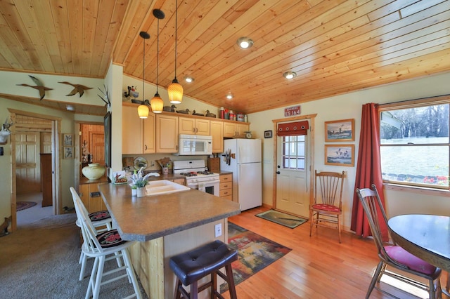 kitchen featuring white appliances, wood ceiling, a sink, vaulted ceiling, and a kitchen breakfast bar