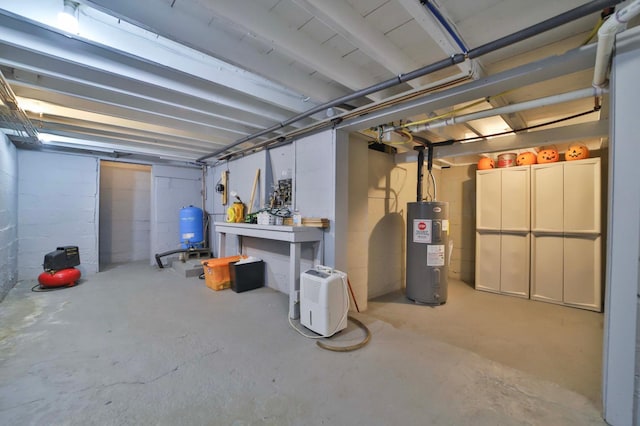 unfinished basement featuring water heater and a water pressure tank