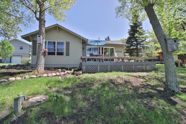 rear view of property featuring a wooden deck and a yard