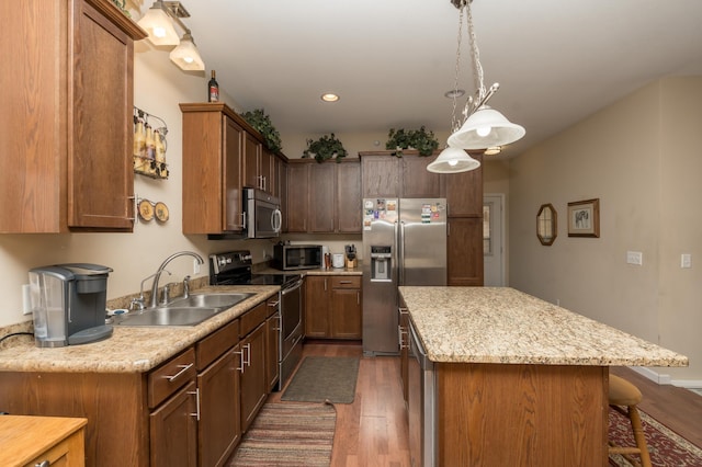 4129 Jarmann Ln, Shakopee, MN 55379 - kitchen with a sink, dark wood finished floors, a kitchen bar, a kitchen island, and appliances with stainless steel finishes