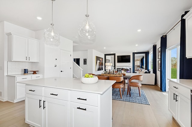 529 Rolling Hills Ln, Delano, MN 55328 - kitchen featuring light countertops, light wood-style floors, backsplash, a kitchen island, and white cabinets