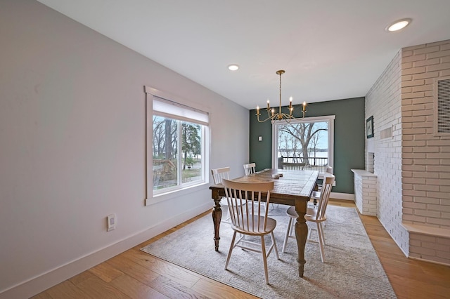 dining area featuring recessed lighting, wood finished floors, baseboards, and a notable chandelier