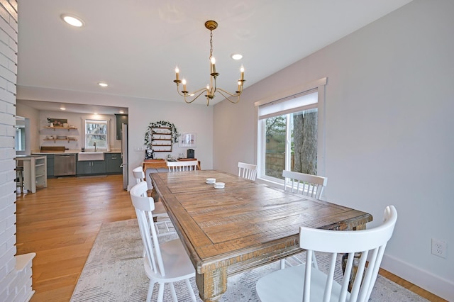 dining room featuring recessed lighting, a wealth of natural light, a notable chandelier, and light wood-style floors