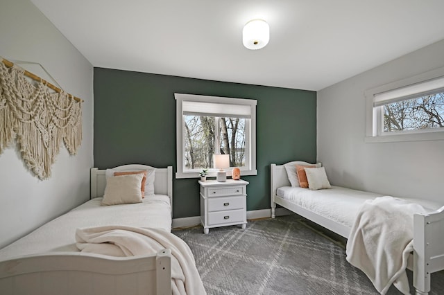 bedroom with baseboards and dark carpet
