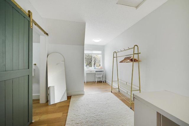 bedroom with light wood-type flooring and a barn door